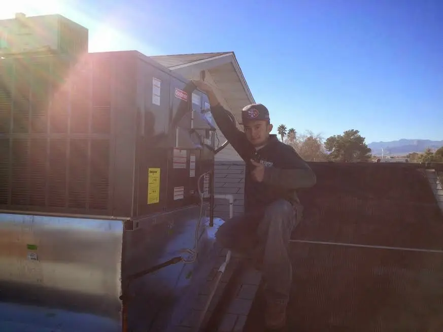 HVAC technician performing Air Duct Repair on a rooftop unit in Hot Springs